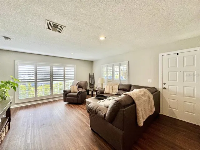 a spacious bedroom with a bed and wooden floor