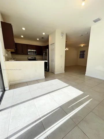 a view of kitchen with stainless steel appliances kitchen island sink and refrigerator