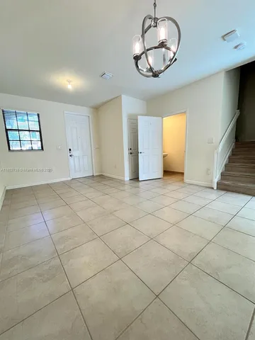 an empty room with a ceiling fan and window