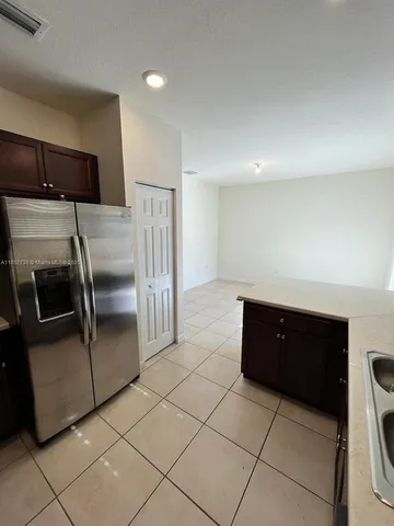 a kitchen with granite countertop a refrigerator and a cabinets