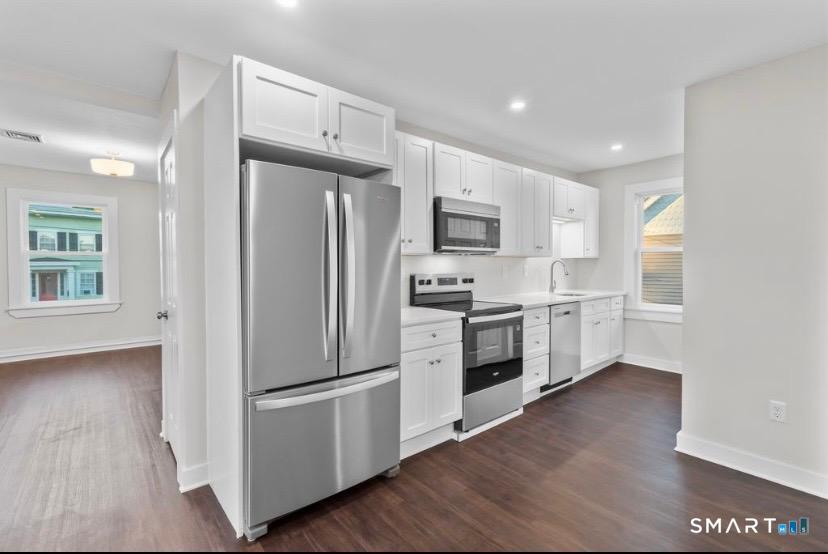 a kitchen with white cabinets and stainless steel appliances