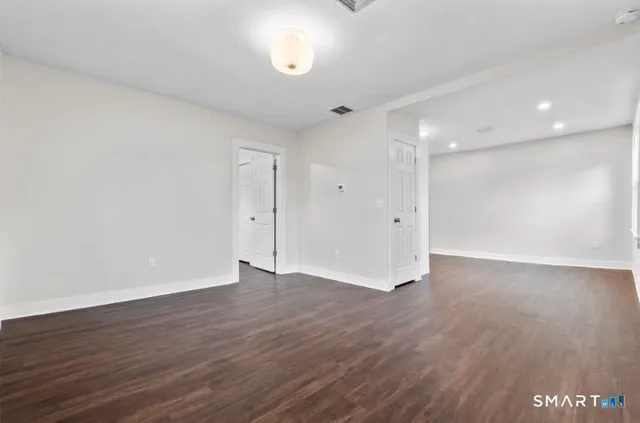 a view of an empty room with wooden floor