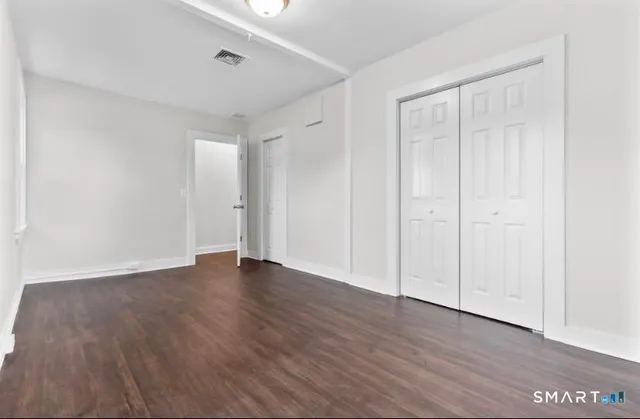 a view of an empty room with wooden floor