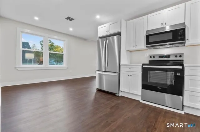 a kitchen with stainless steel appliances granite countertop a stove a microwave and a refrigerator