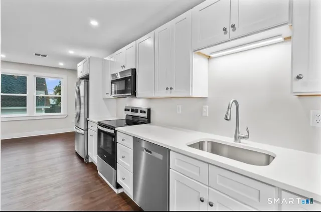 a kitchen that has a sink and a stove top oven