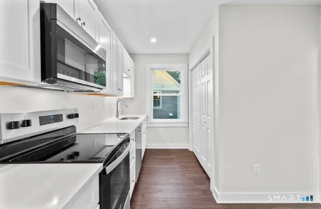 a kitchen with stainless steel appliances granite countertop a stove and a microwave