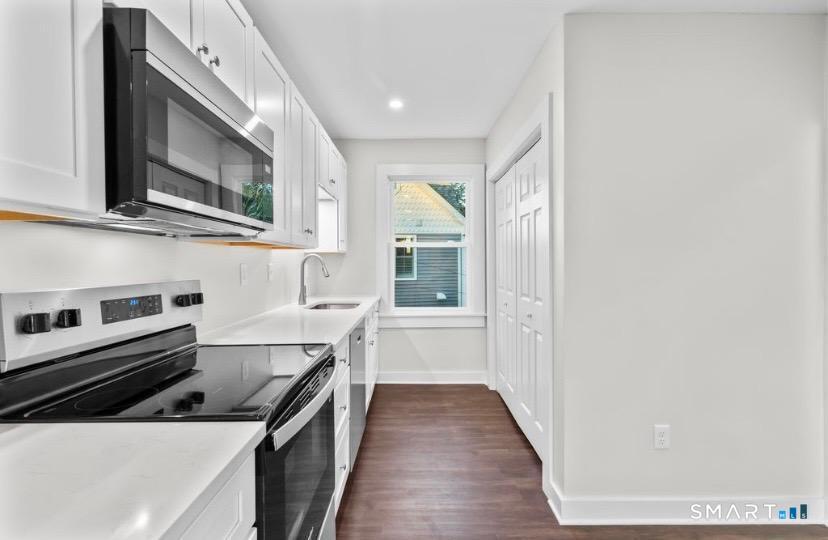 57 East Main Street, Unit 2 Branford, CT 06405 - Photo 5 of 17 a kitchen with stainless steel appliances granite countertop a stove and a microwave