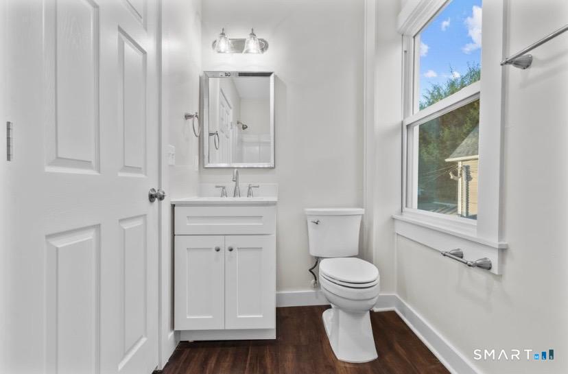 57 East Main Street, Unit 2 Branford, CT 06405 - Photo 6 of 17 a bathroom with a toilet a sink a vanity and mirror