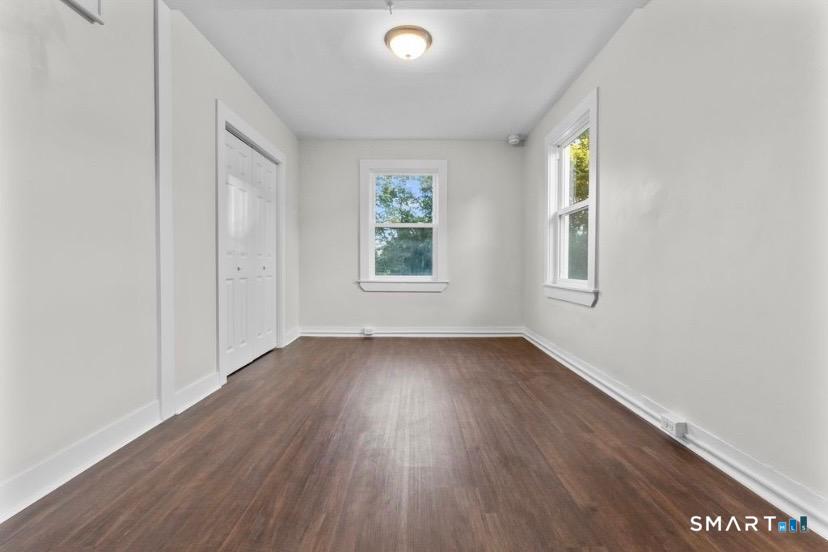 57 East Main Street, Unit 2 Branford, CT 06405 - Photo 10 of 17 an empty room with wooden floor and windows