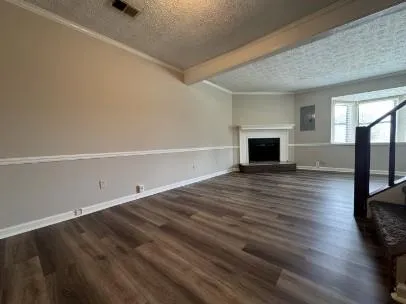 a view of empty room with wooden floor and fireplace