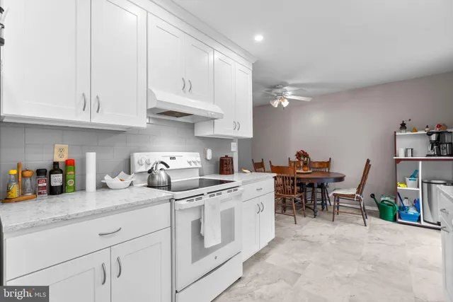 a kitchen with white cabinets and appliances