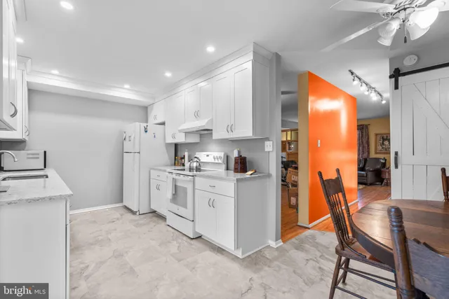 a kitchen with white cabinets and stainless steel appliances