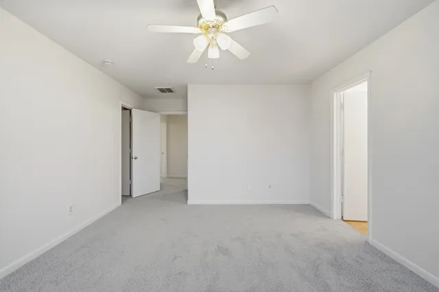 an empty room with a ceiling fan and a window