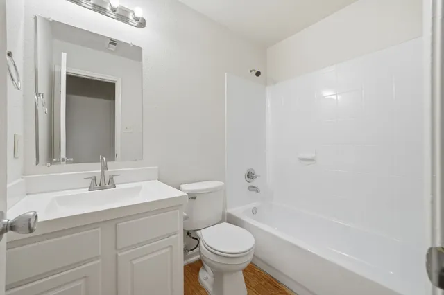 a bathroom with a sink toilet vanity and tub
