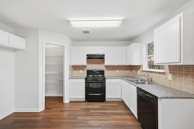 a kitchen with a stove top oven and cabinets