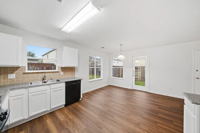 a view of a kitchen with a sink cabinets and wooden floor