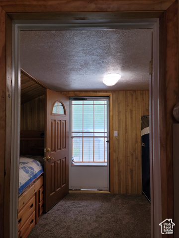 97 East Main Street Stockton, UT 84071 - Photo 53 of 58 Bedroom featuring a textured ceiling, dark colored carpet, and wooden walls