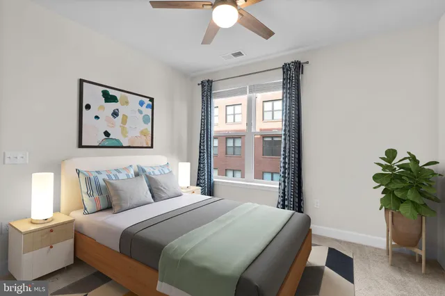 a bedroom with a large bed and a potted plant