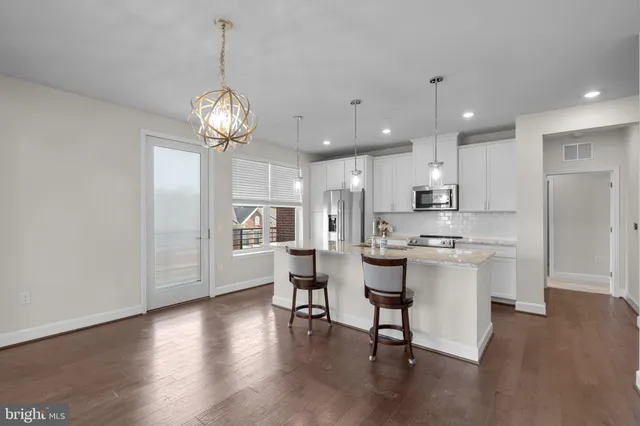 a view of a dining room with furniture a chandelier and wooden floor