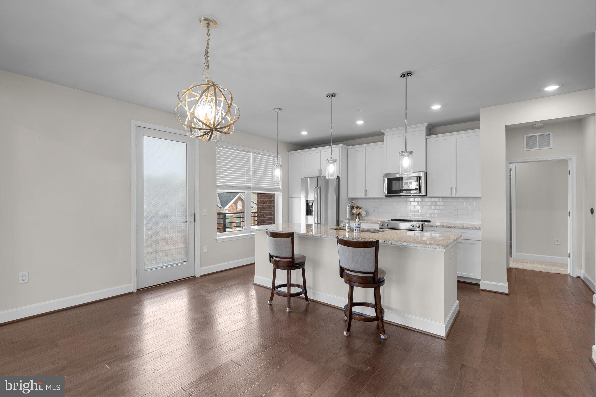 2960 Vaden Drive, Unit 2312 Fairfax, VA 22031 - Photo 20 of 46 a view of a dining room with furniture a chandelier and wooden floor