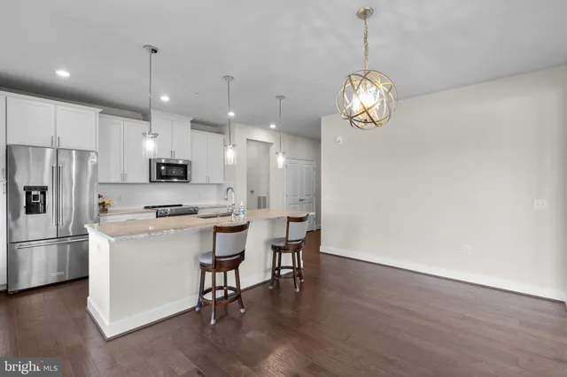 a view of a kitchen with dining table and stainless steel appliances