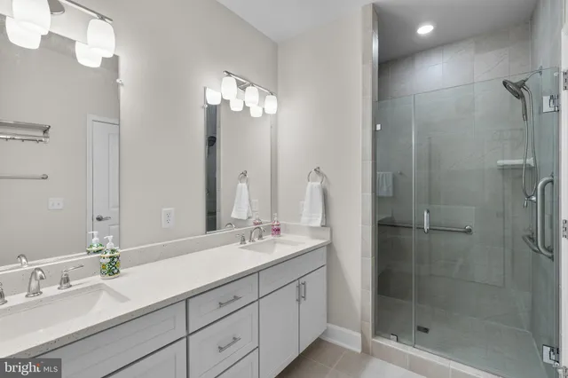 a bathroom with a double vanity sink mirror and shower