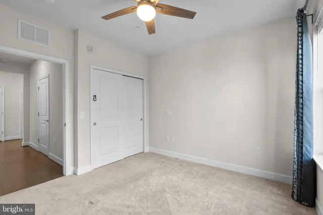 an empty room with a chandelier fan