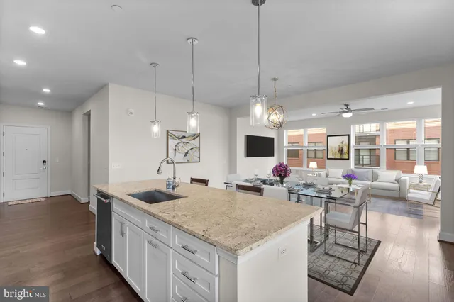 a kitchen with stainless steel appliances granite countertop a sink a stove and a wooden floor