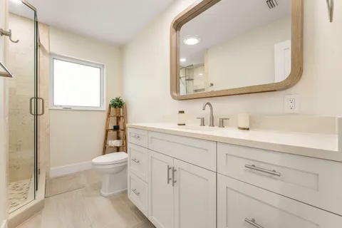 a bathroom with a sink a toilet and shower