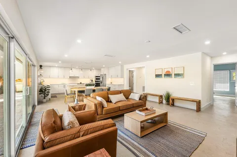 a living room with furniture kitchen view and a table