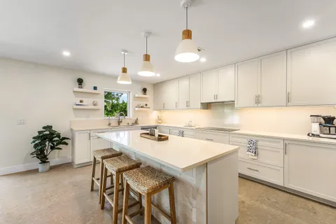 a kitchen with a sink a center island and cabinets