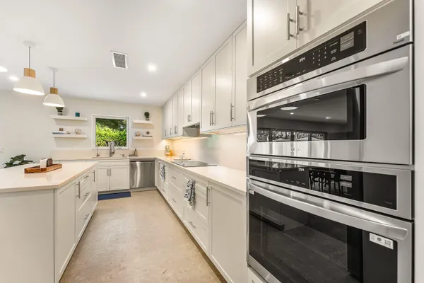 a kitchen with stainless steel appliances kitchen island granite countertop a stove a sink and a microwave