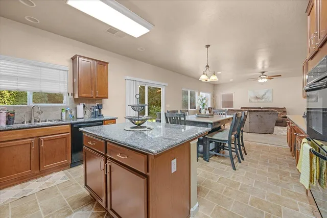 a kitchen with stainless steel appliances granite countertop table chairs sink and cabinets
