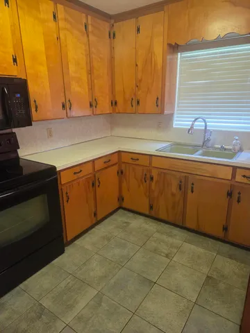 a kitchen with a sink cabinets and wooden floor