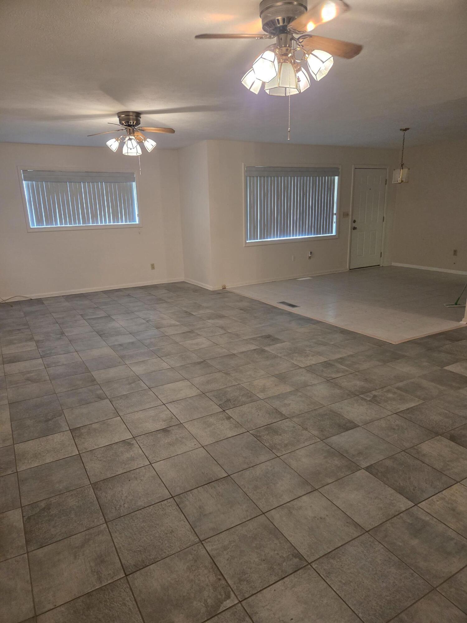 814 Maple Street Chipley, FL 32428 - Photo 12 of 15 a view of an empty room with a chandelier fan and kitchen view