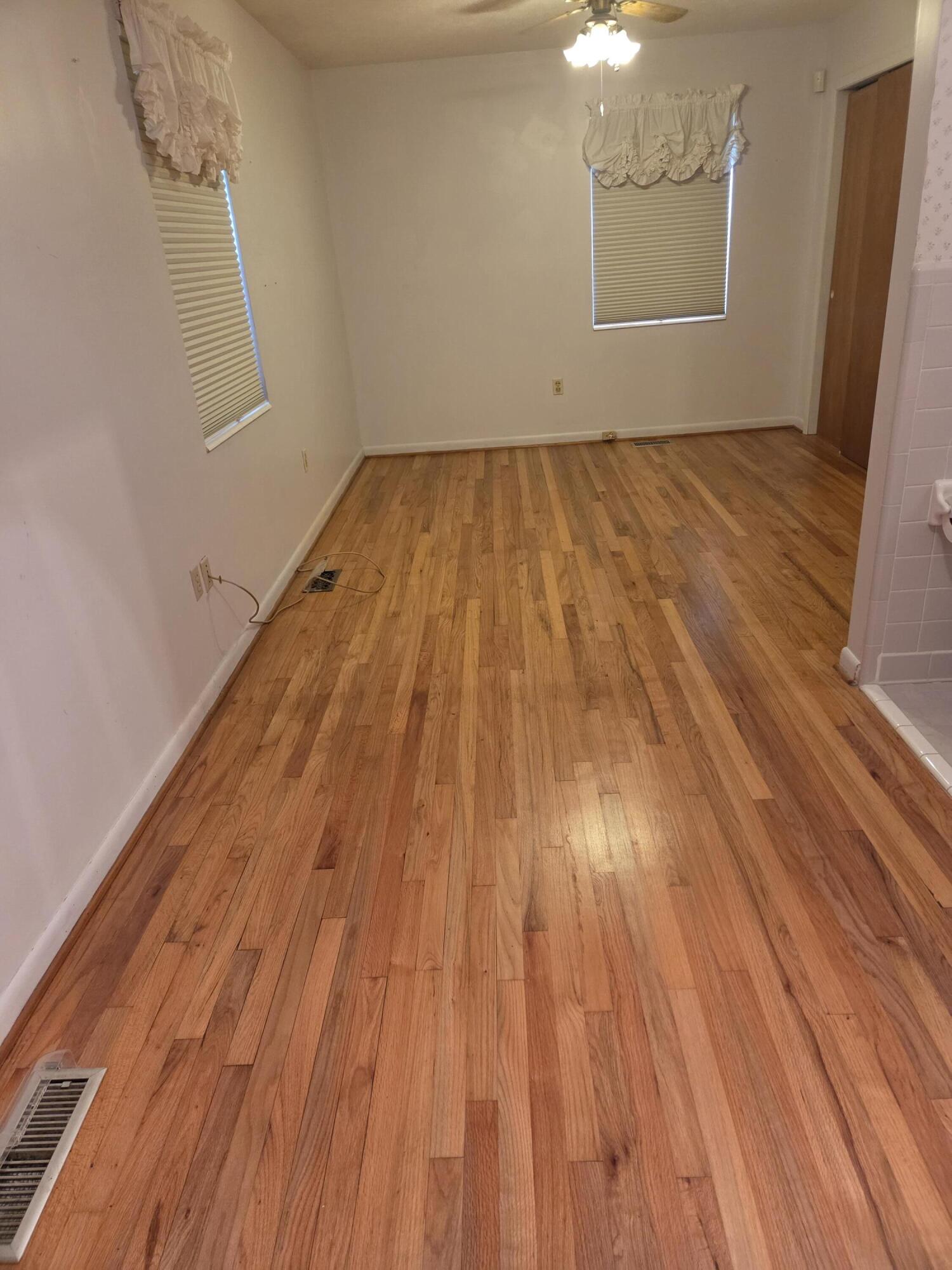 814 Maple Street Chipley, FL 32428 - Photo 14 of 15 an empty room with wooden floor and windows