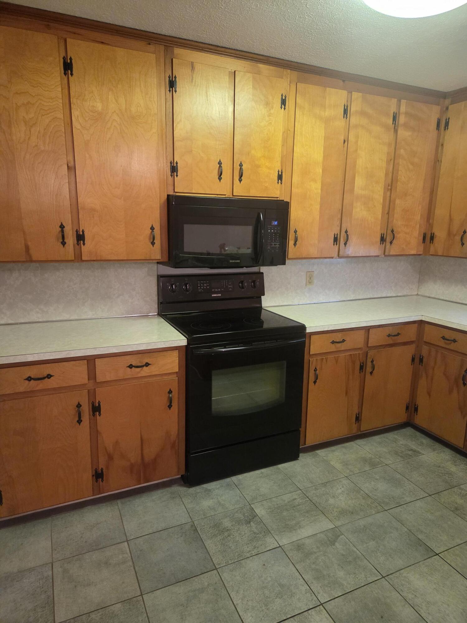814 Maple Street Chipley, FL 32428 - Photo 10 of 15 a kitchen with stainless steel appliances granite countertop a stove a sink and a microwave