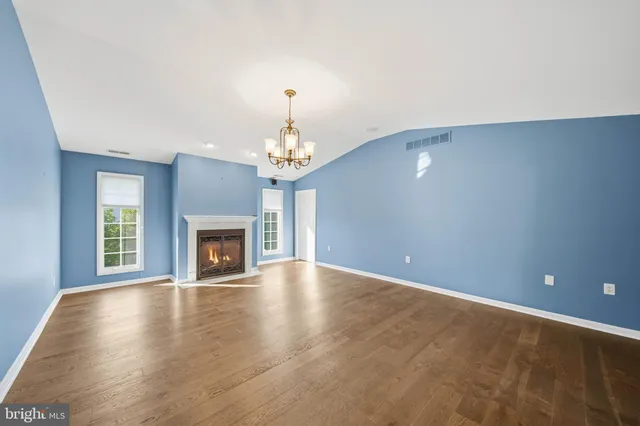 a view of an empty room with a fireplace and a window