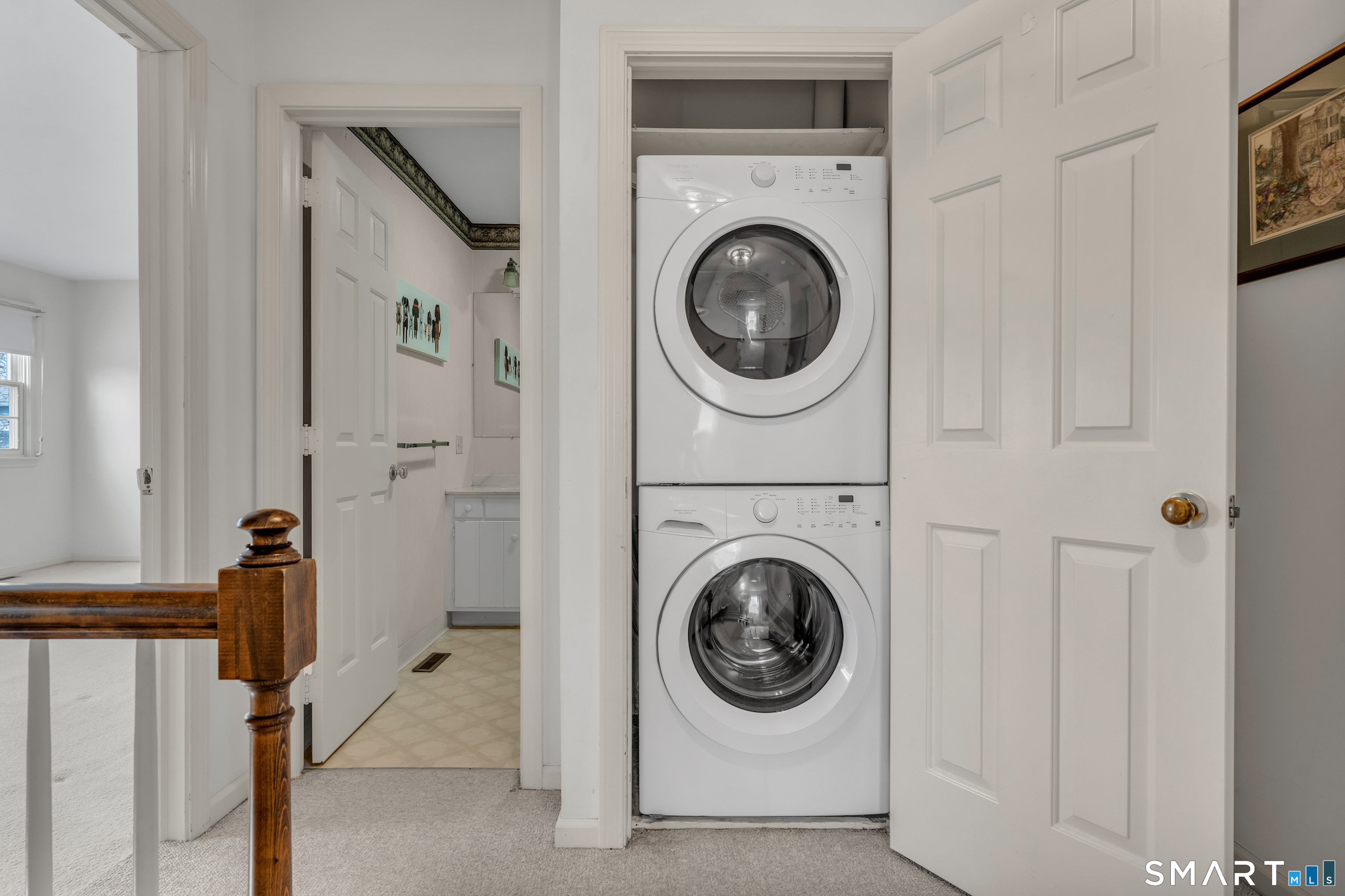 23 Hampshire Road, Unit 23 Madison, CT 06443 - Photo 31 of 39 Upstairs hallway with stackable washer and dryer as well as a linen closet.