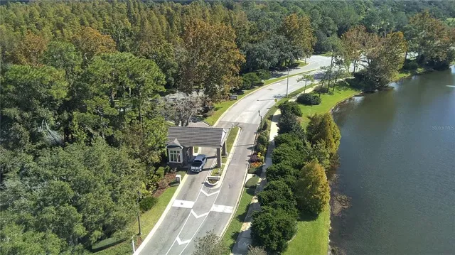 an aerial view of a house with a yard and lake view