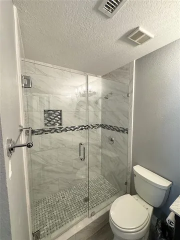 a bathroom with a toilet and a shower