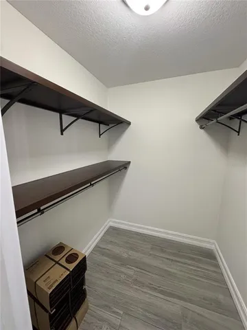 a view of a room with wooden floor and a ceiling fan