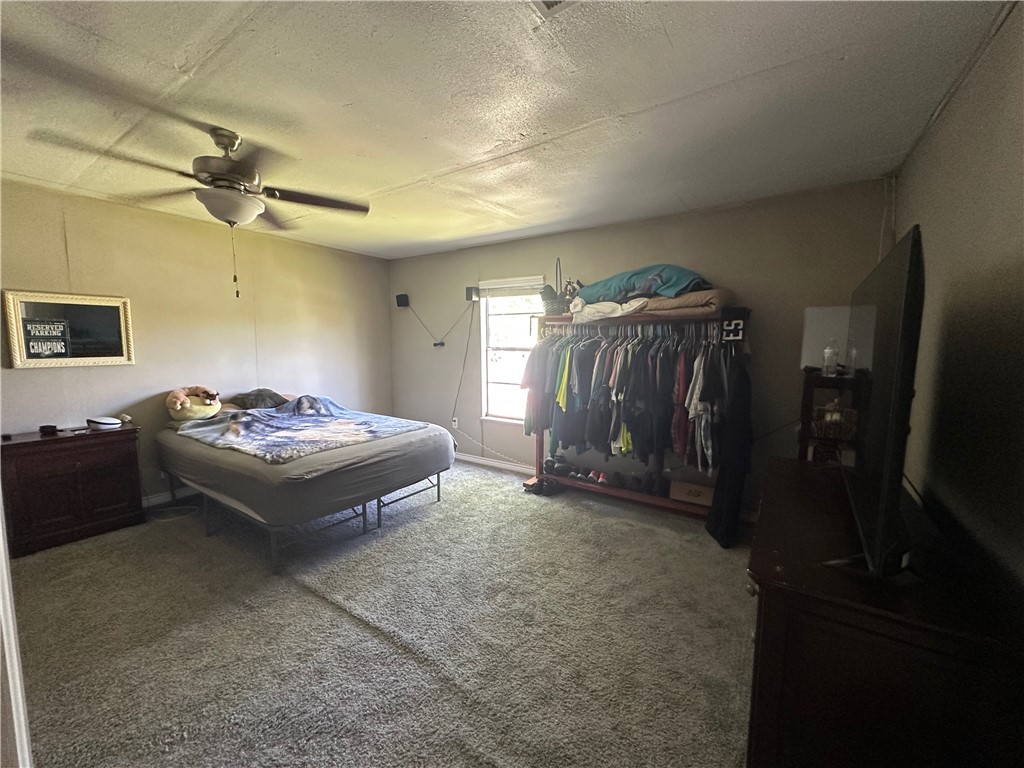 409 Houston Street Mexia, TX 76667 - Photo 18 of 33 a spacious bedroom with a bed and a mirror