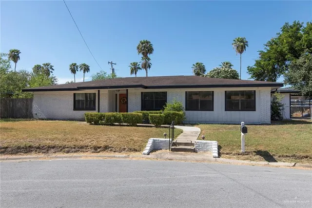 a front view of house with yard and trees around