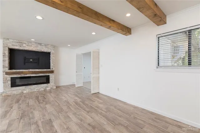 a view of room with stainless steel appliances wooden floor and window