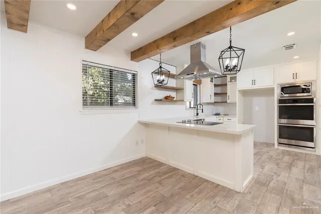 a kitchen with stainless steel appliances granite countertop a sink cabinets and wooden floor