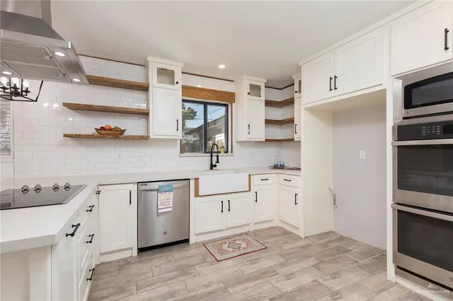 a kitchen with white cabinets and appliances