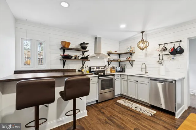 a kitchen with stainless steel appliances granite countertop a sink and a refrigerator