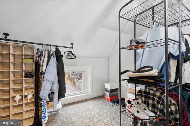 a view of walk in closet with clothes and shoes