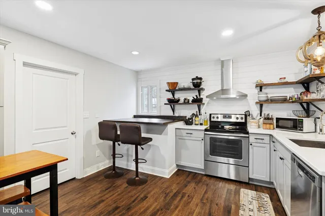 a kitchen with stainless steel appliances a stove a sink and a refrigerator